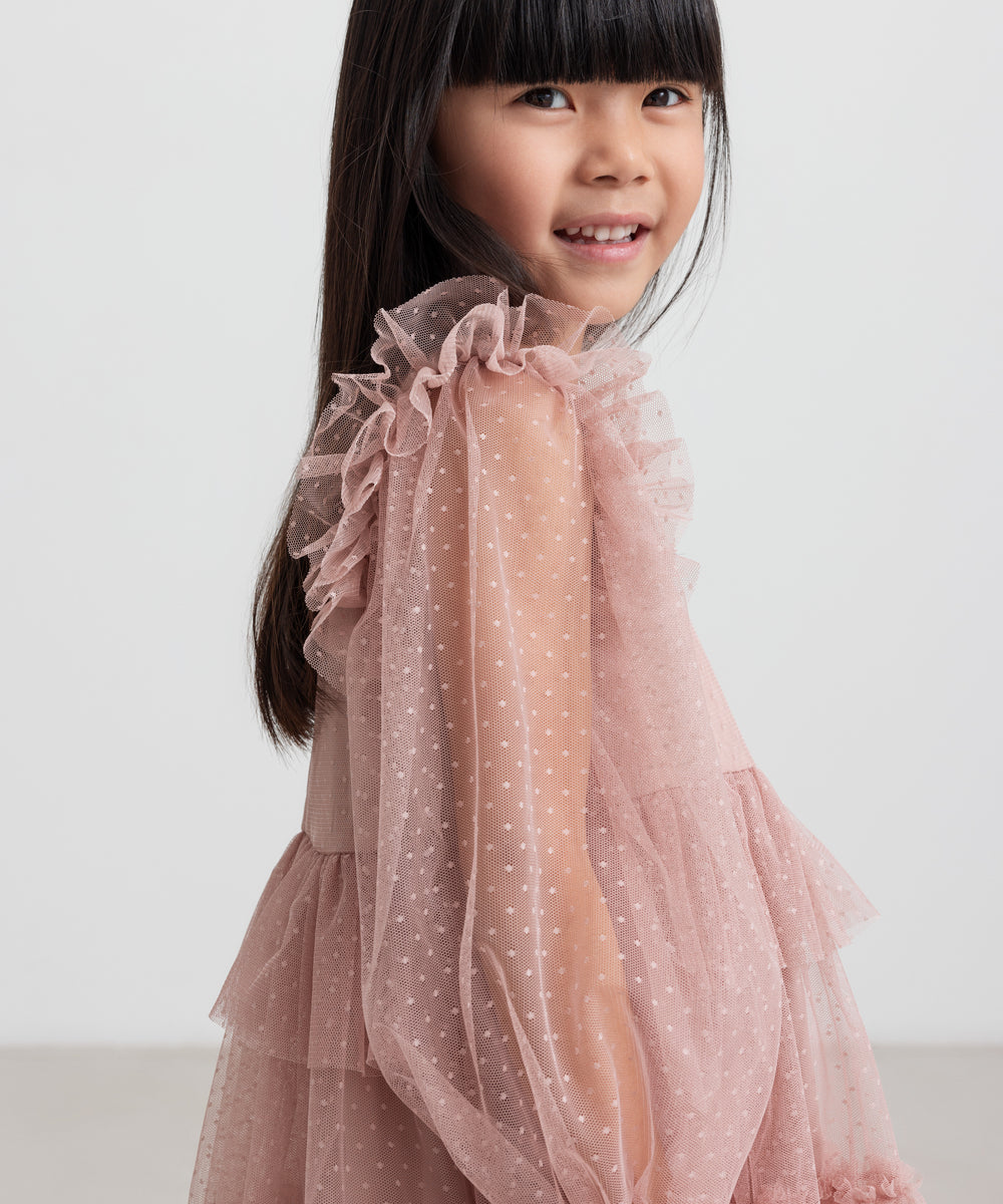 Børn iført rosa tylkjole med volanger på ærmerne
