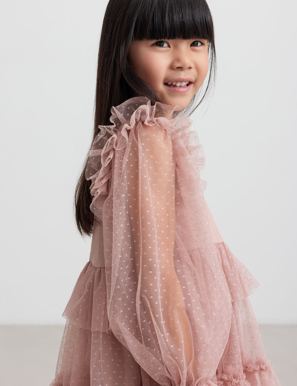 Børn iført rosa tylkjole med volanger på ærmerne