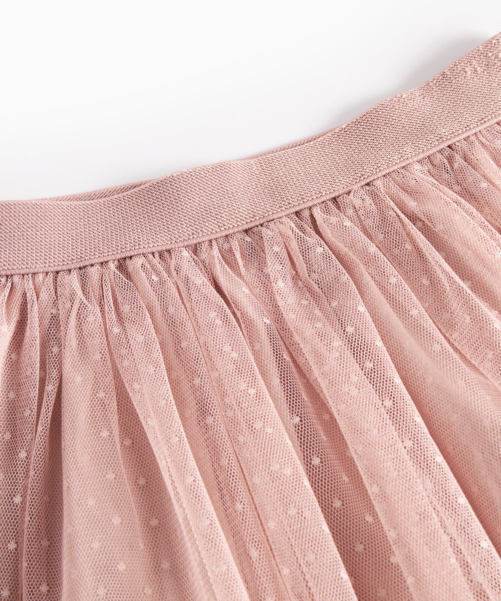 Detaljebillede af elastik i taljen på lyserød tylnederdel med prikmønster