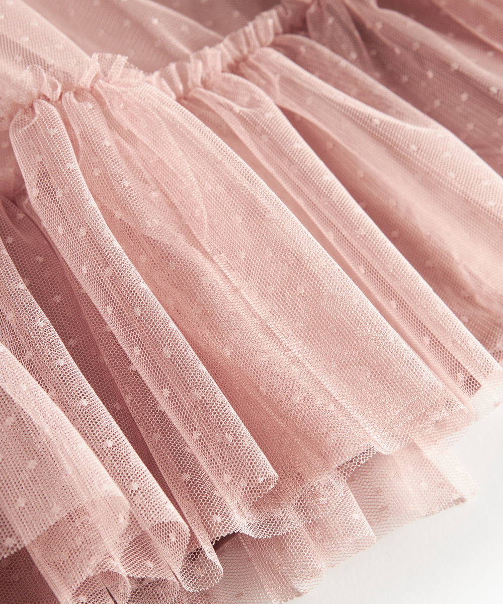 Nærbillede af lagdelt lyserød tylnederdel med fint prikmønster