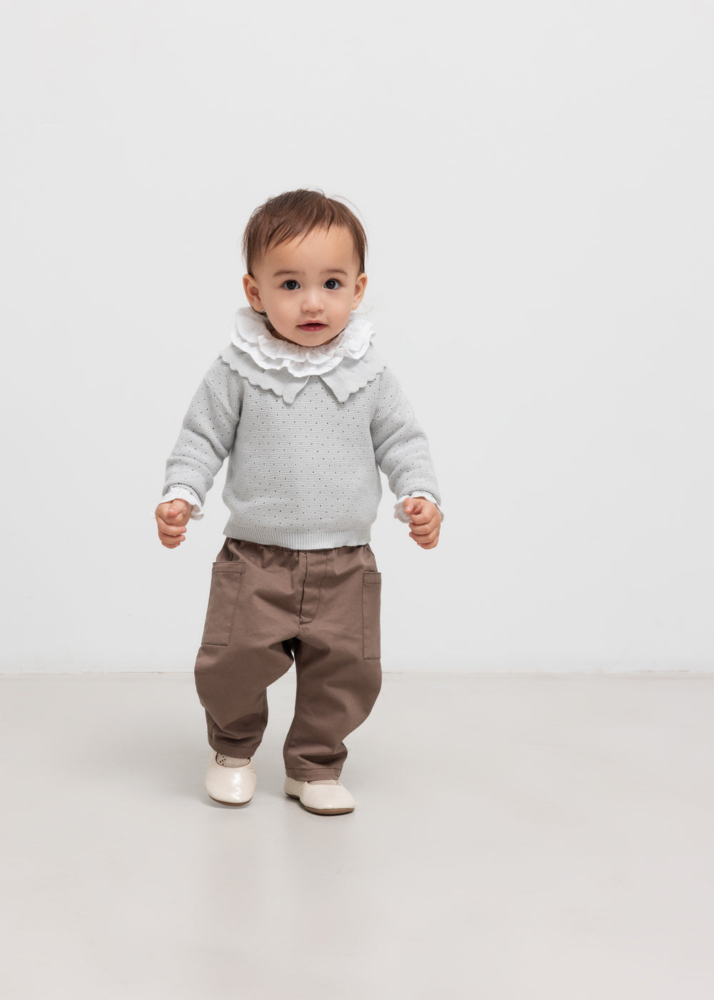 Børn iført khaki bukser og grå strikbluse