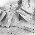 Detalje af flæsekrave på grå strikbluse med hulmønster