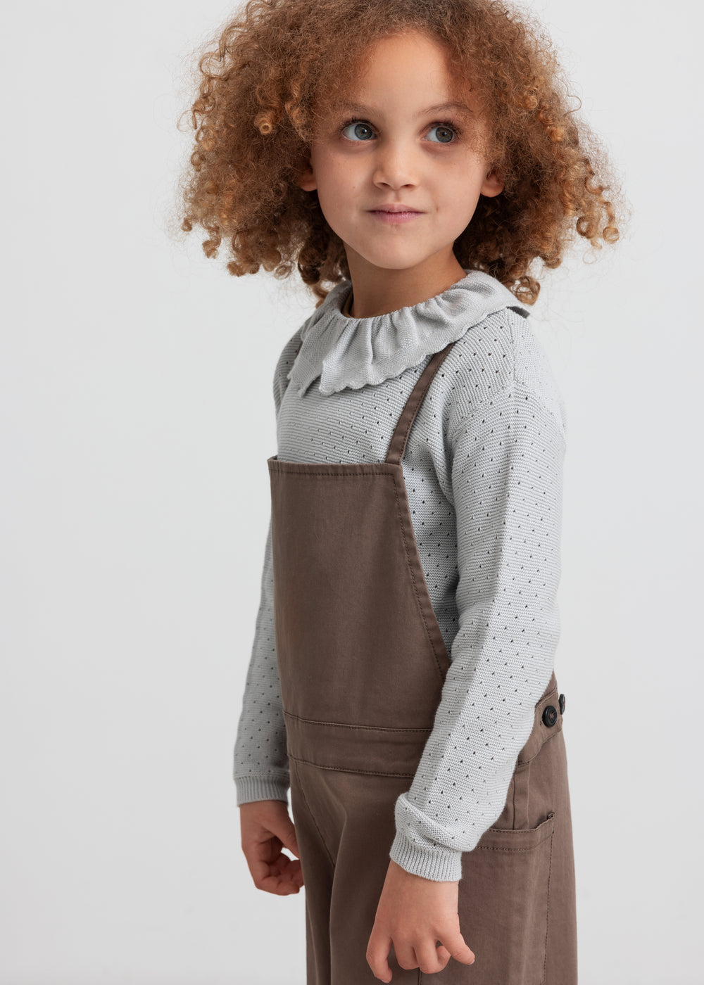 Børn iført kaki selebukser og strikbluse