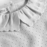 Detalje af flæsekrave på grå strikbluse med hulmønster