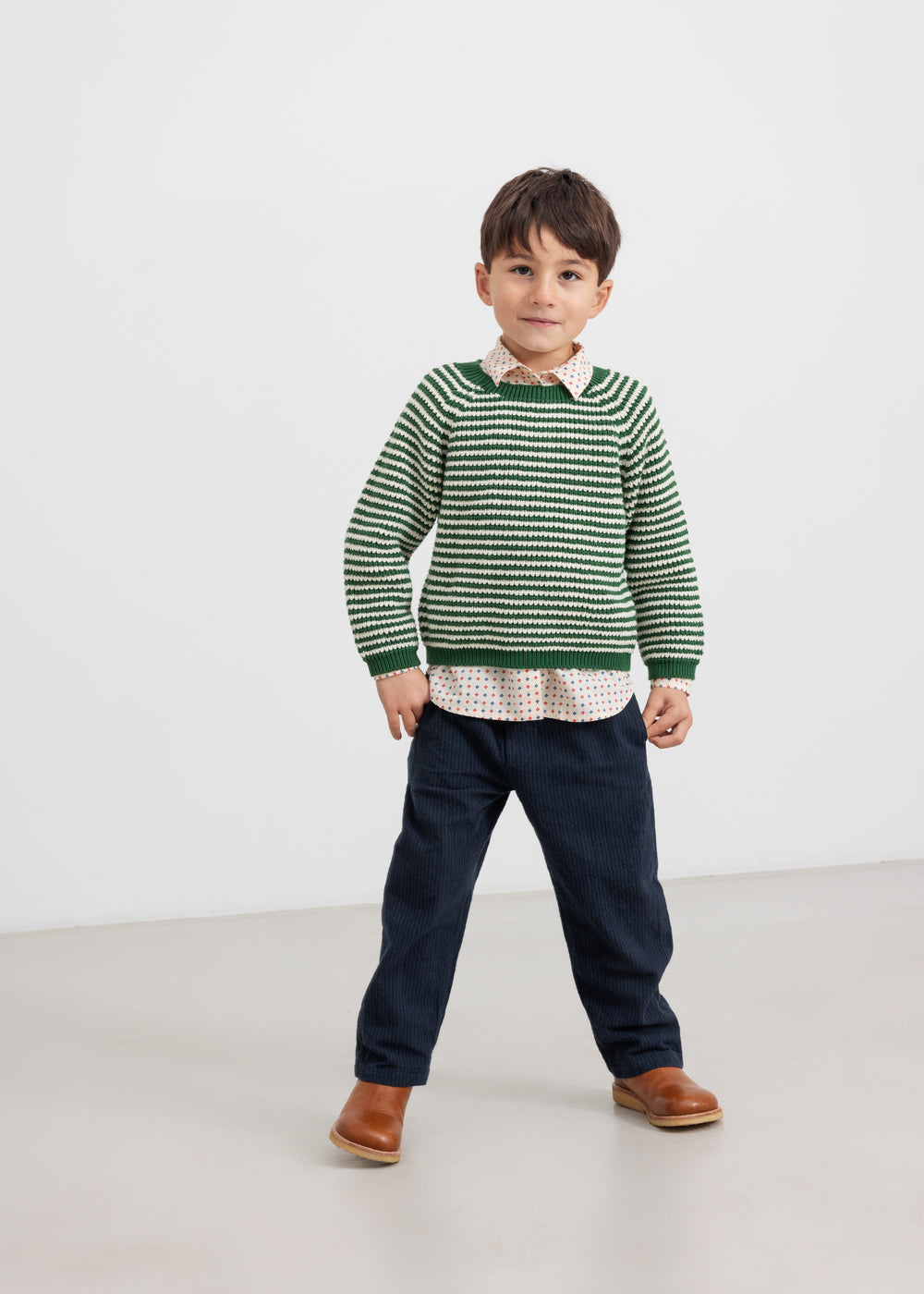 Dreng i grøn stribet striktrøje og jeans set forfra