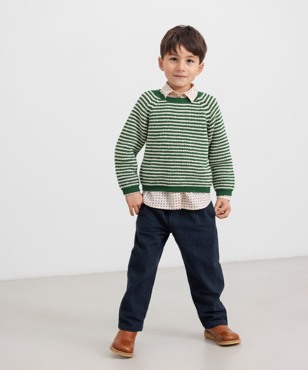 Børn iført mørkeblå bukser og grøn striktrøje