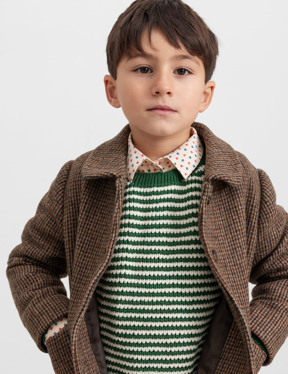 Boy wearing green striped sweater with brown jacket