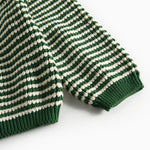 Detaljebillede af ærme på grøn og hvid stribet striktrøje