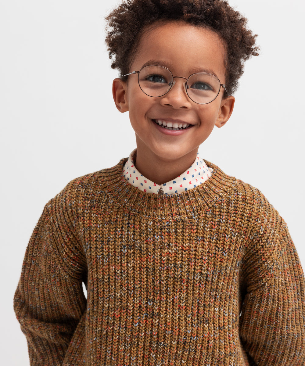 Glad dreng iført brunmeleret striktrøje
