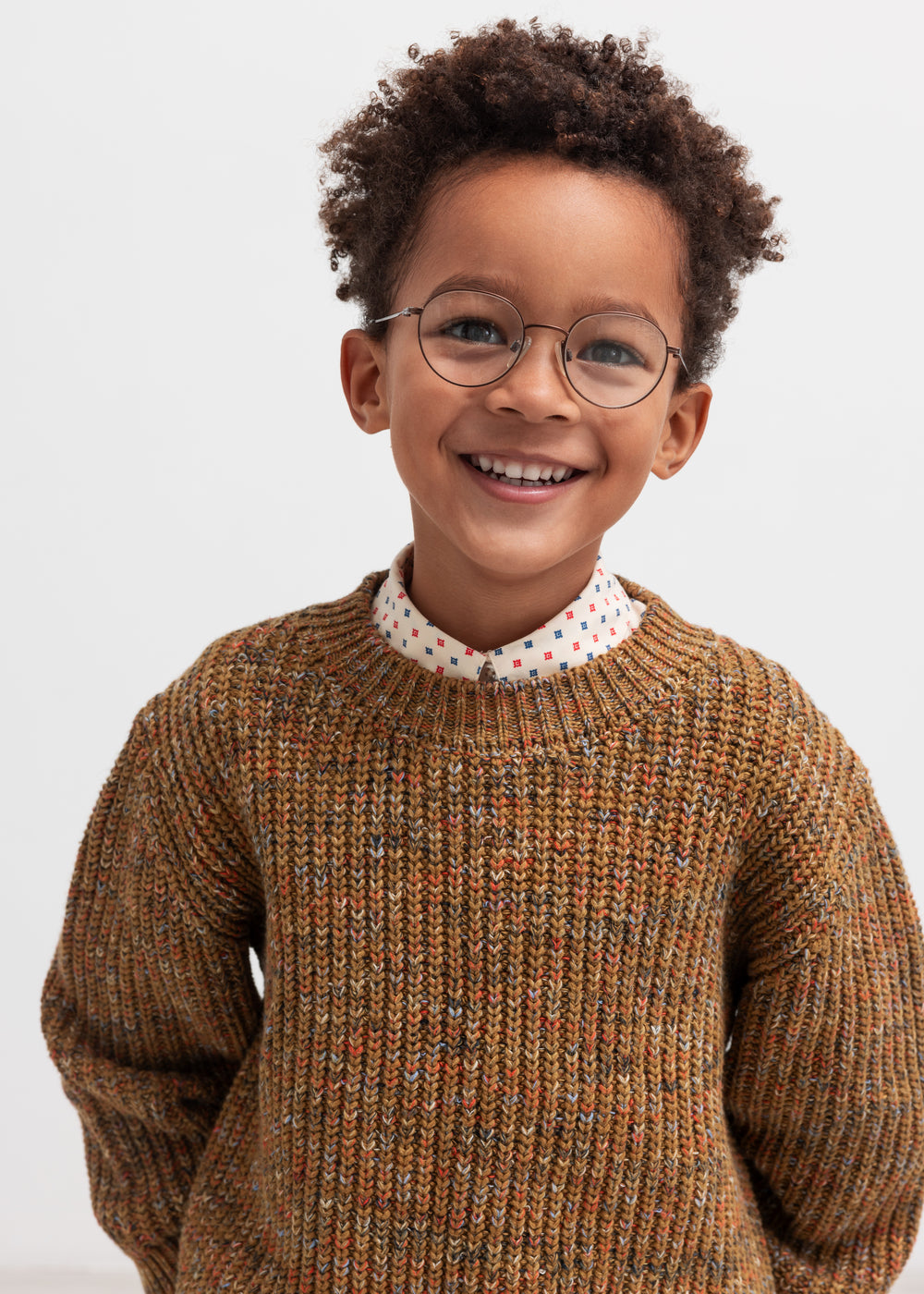 Glad dreng iført brunmeleret striktrøje