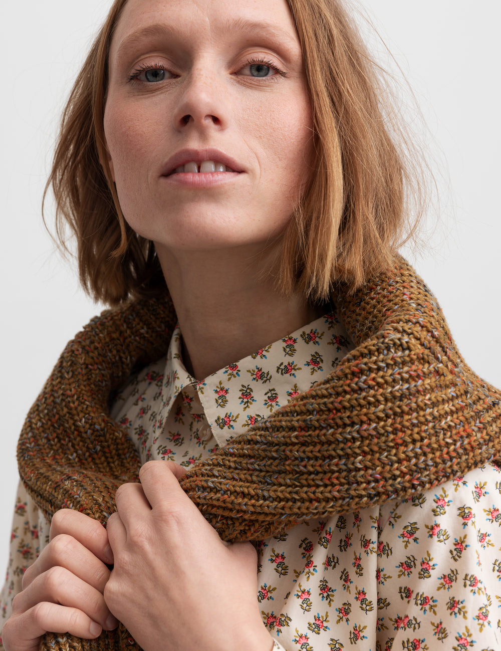 Kvinde iført blomstret skjorte med knaplukning og lange ærmer