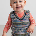 Baby iført mønstret strikvest over stribet bluse