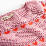 Nærbillede på lyserød strikkjole til børn med røde hjerter