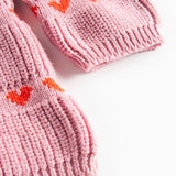 Nærbillede på lyserød strikkjole til børn med røde hjerter