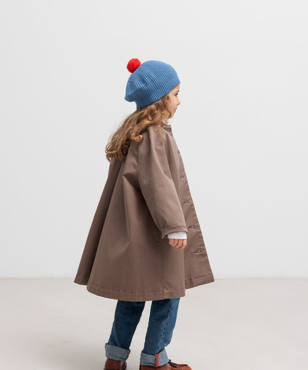 Pige bagfra med blå beret med rød kvast og brun frakke