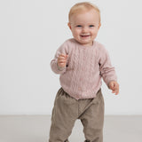 Børn iført lyserød strikcardigan og beige bukser, stående