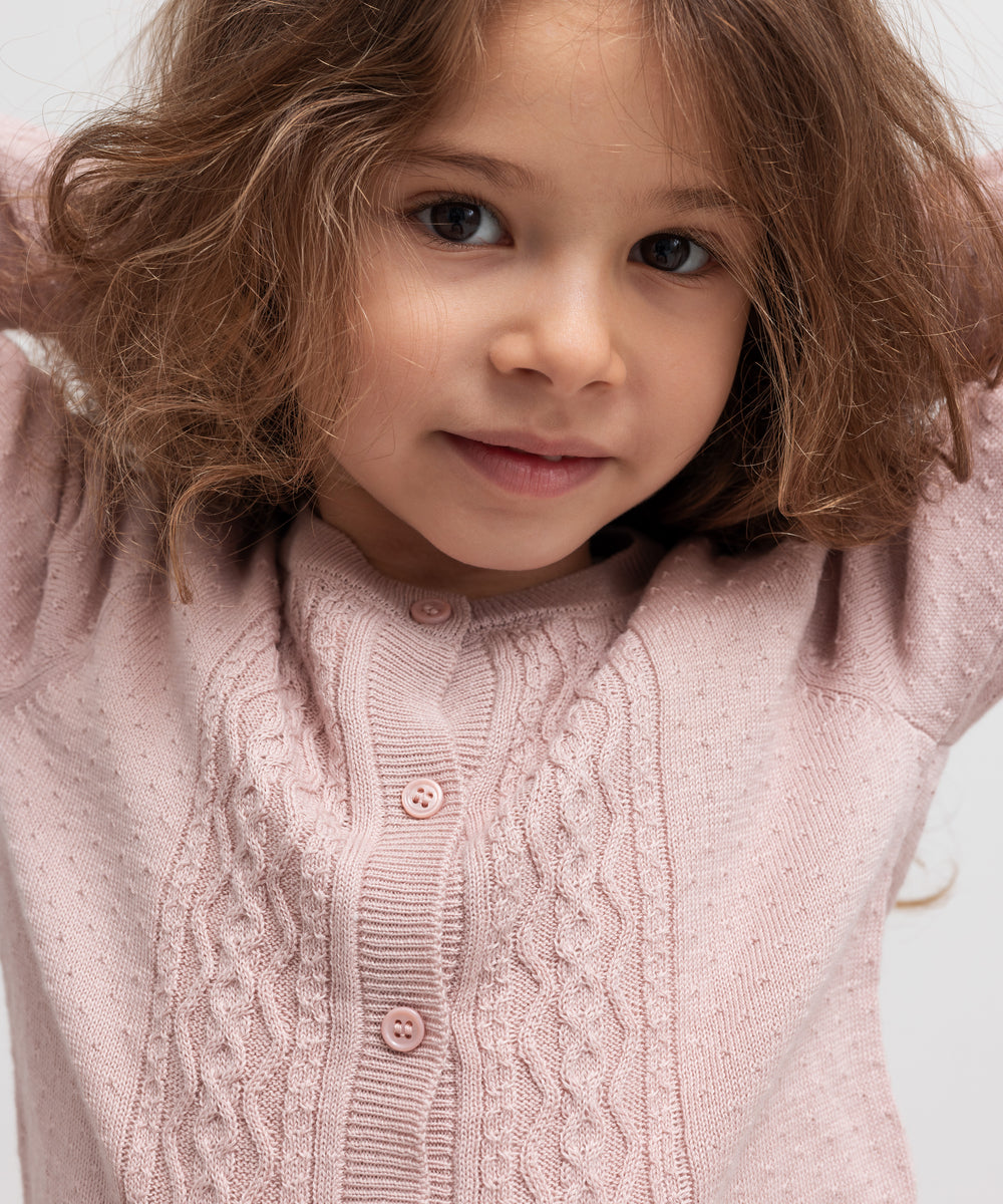 Børn med lyserød strikcardigan og krave, nærbillede