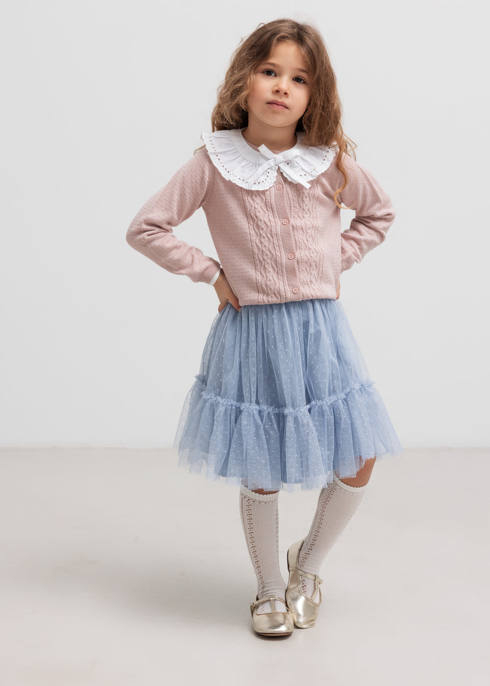 Børn iført blå tylnederdel med lag på lag og bluse med flæsekrave