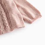 Nærbillede af ærme på lyserød strikcardigan med mønsterstrik