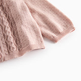 Nærbillede af ærme på lyserød strikcardigan med mønsterstrik