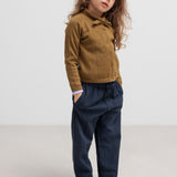 Børn iført mørkeblå bukser og brun strik cardigan