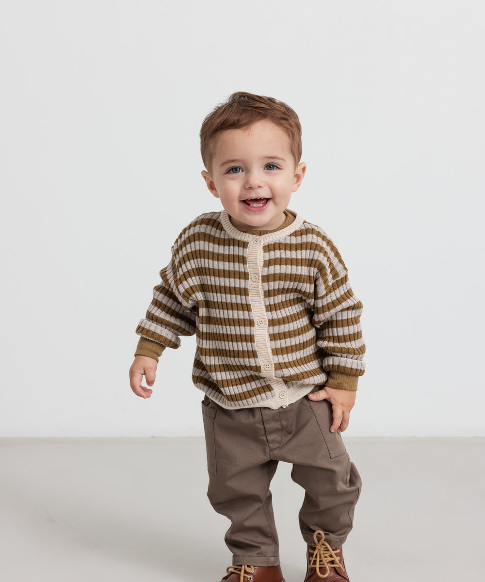 Børn iført stribet strikcardigan med knapper og brune bukser