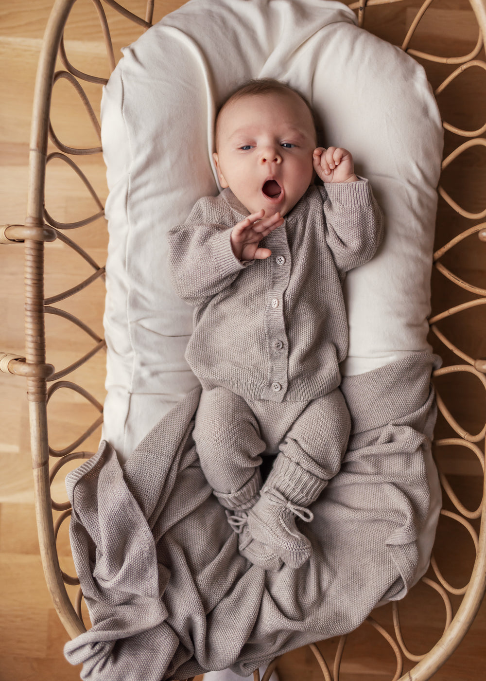 Baby iført beige strik babytøj