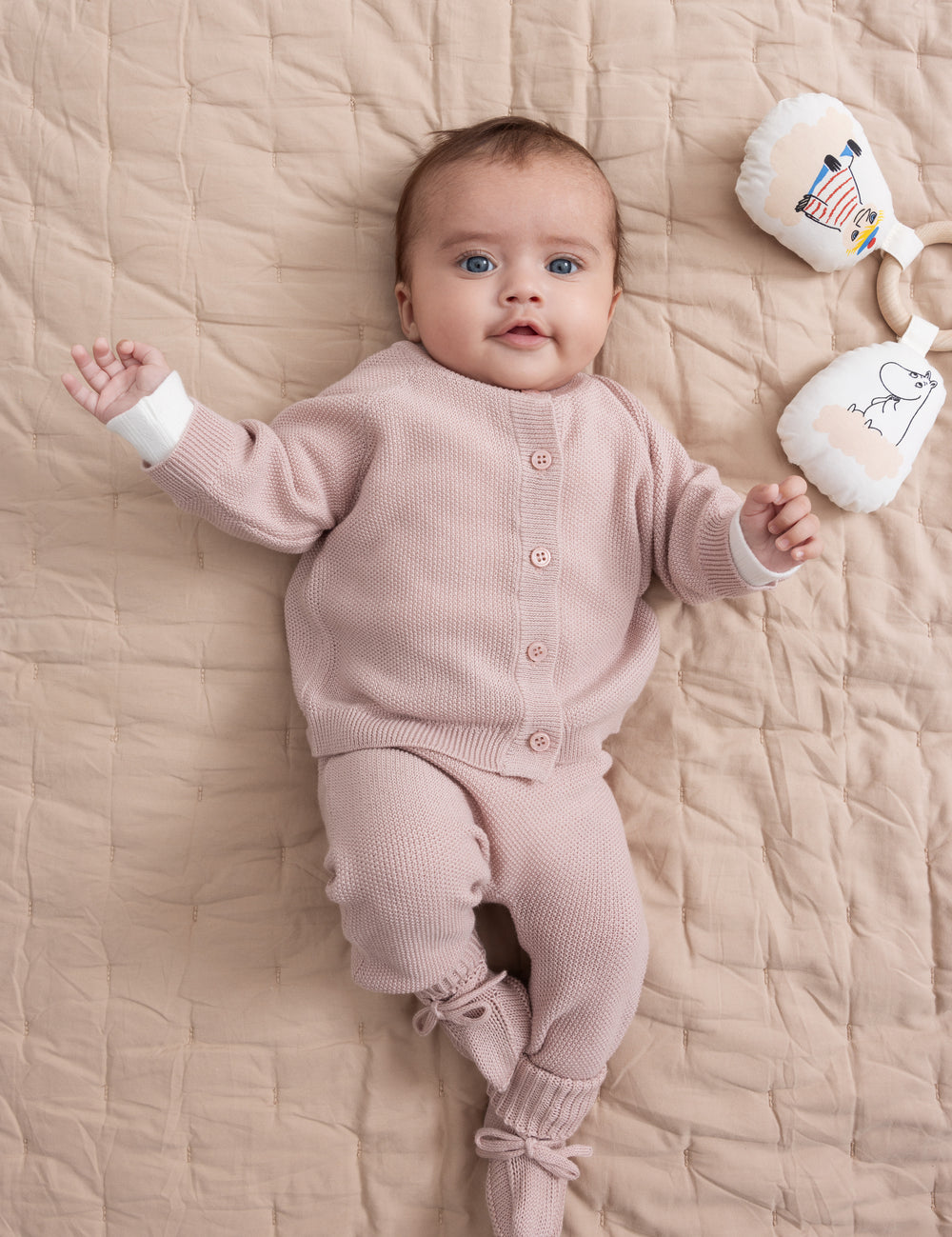 Baby iført lyserød strik babytøj