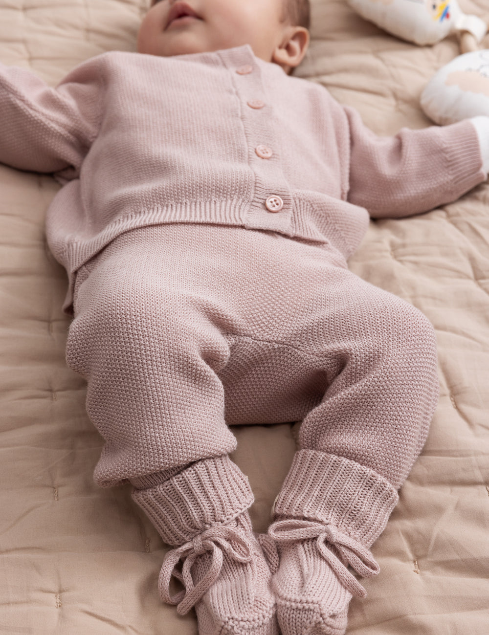 Baby wearing pink knitted set with sweater and pants
