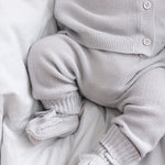 Detalje af babyben i gråt strikket sæt med små strømper