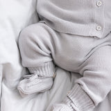 Detalje af babyben i gråt strikket sæt med små strømper