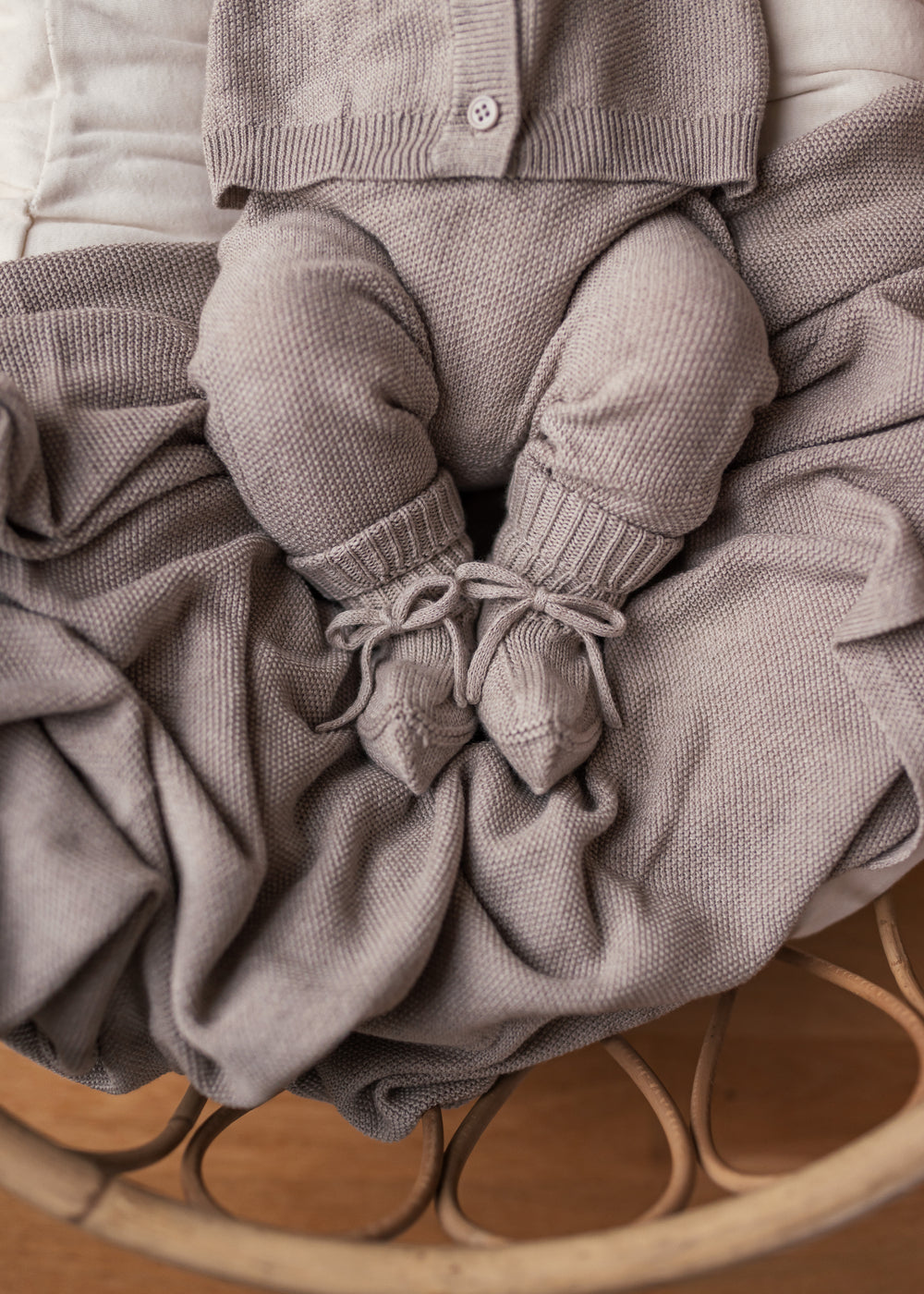 Baby med beige strikket babytæppe