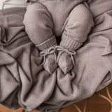 Baby med beige strikket babytæppe