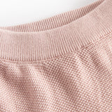 Detalje af halsudskæring på lyserød strikket babytrøje