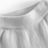 Nærbillede af halsudskæring på grå strikket babytrøje