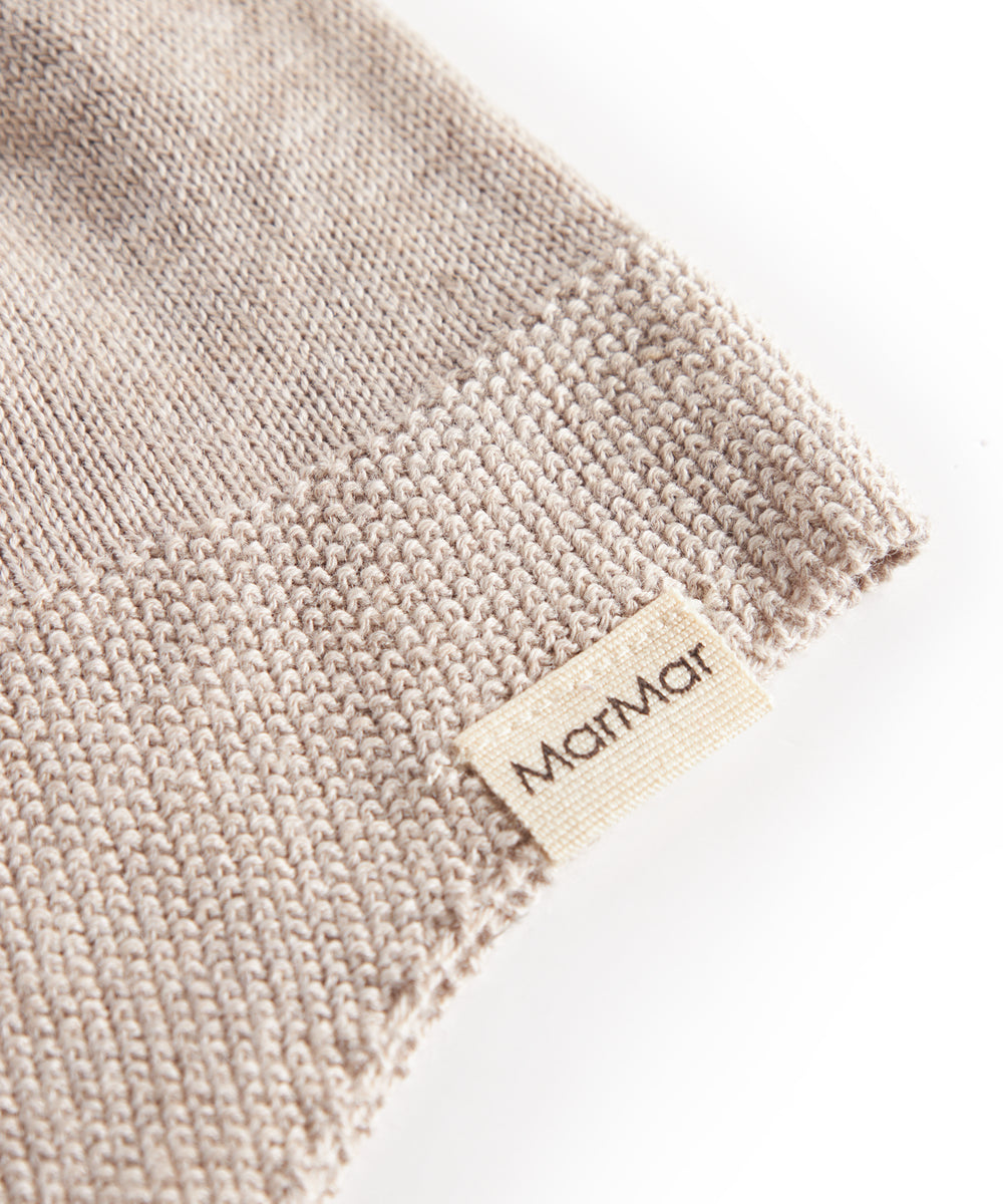 Detalje af beige strikket babyhue med MarMar label