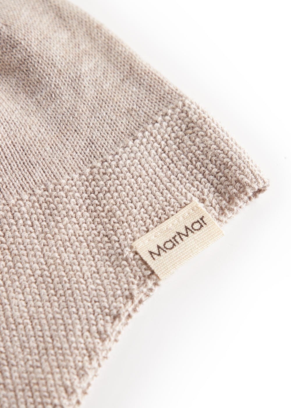 Detalje af beige strikket babyhue med MarMar label