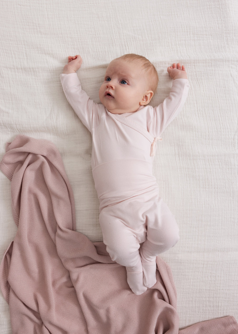 Baby med Lyserød strikket babytæppe