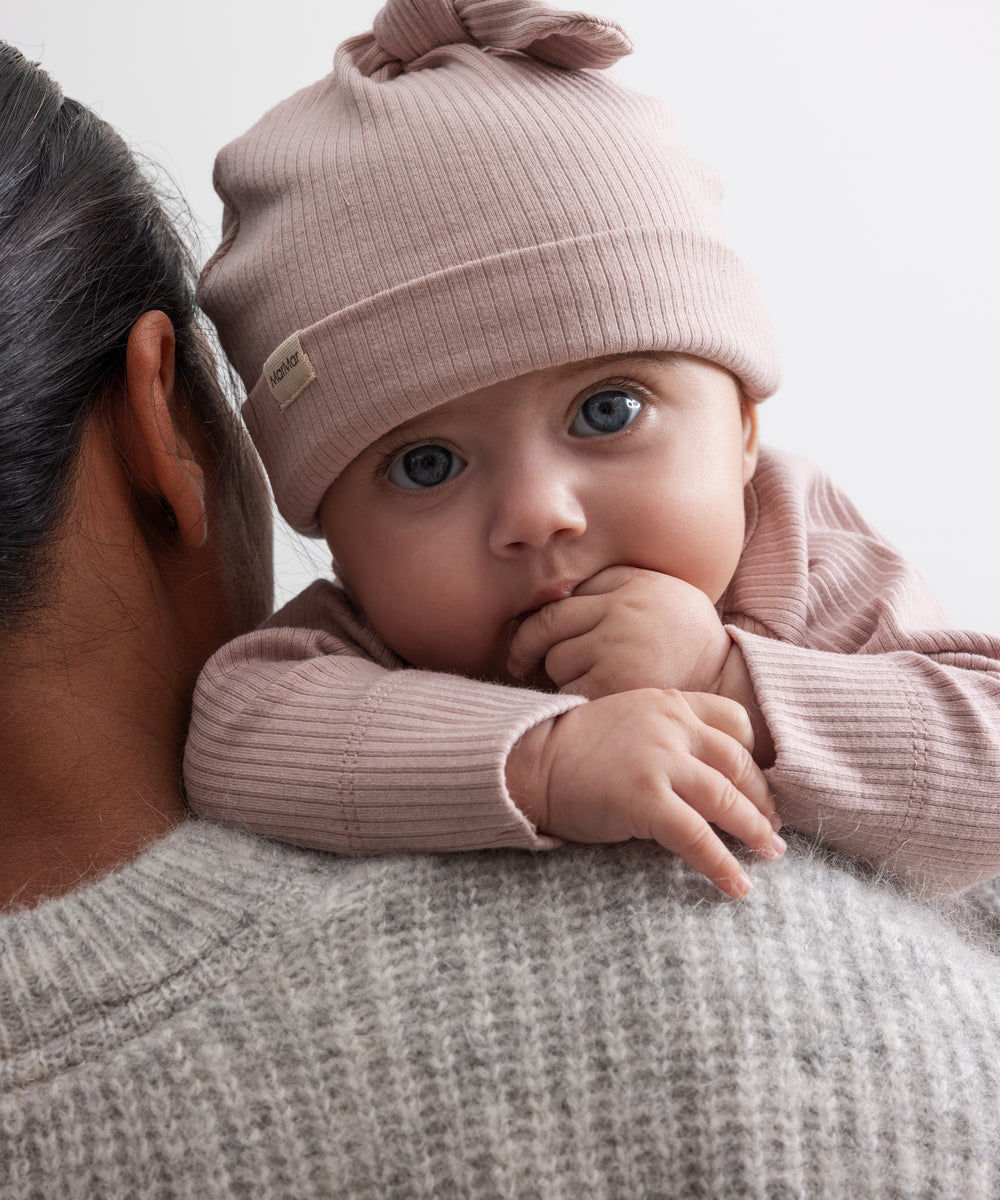 Baby i lyserød ribstrikket babyhue og babybody