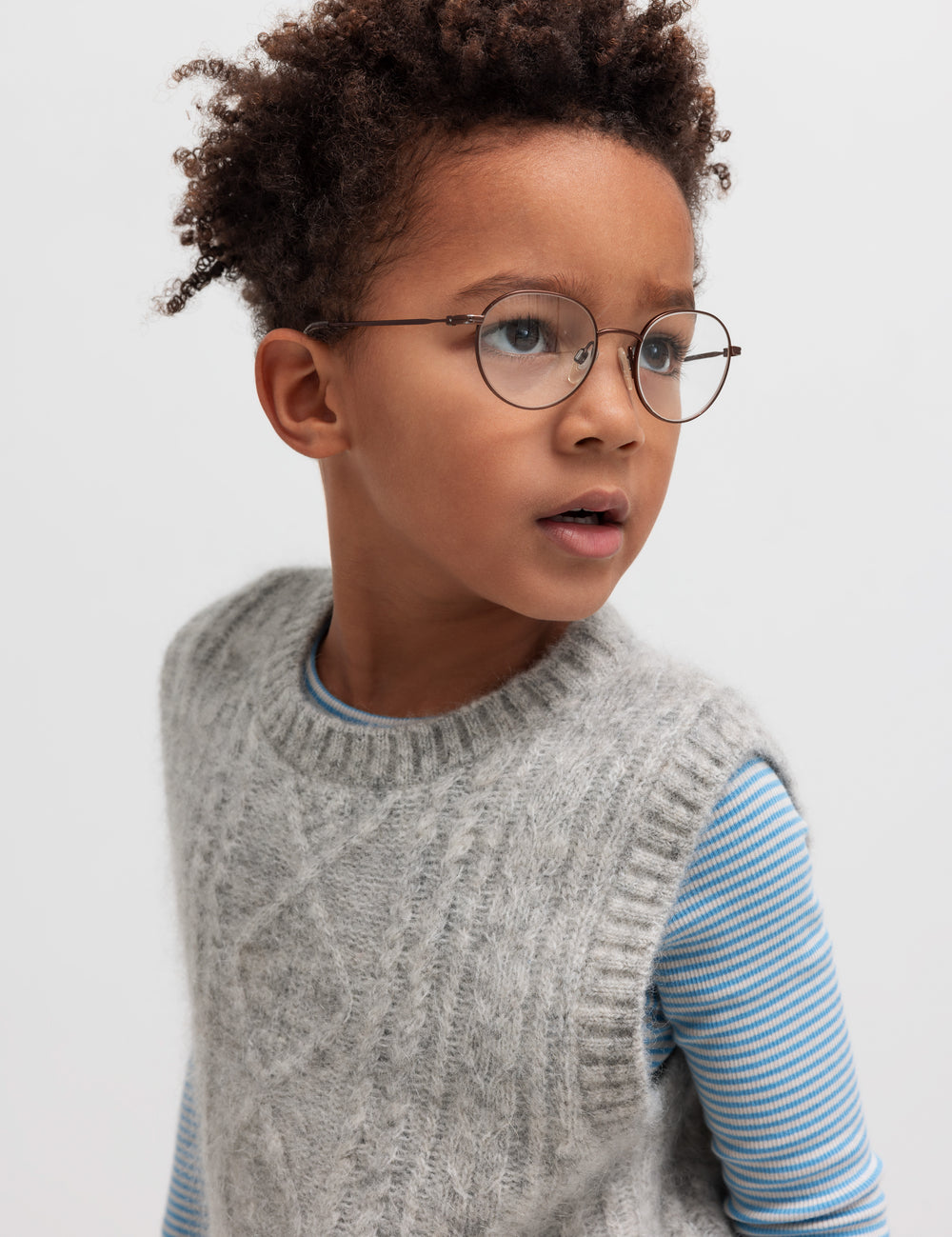 Børn iført grå strikvest over stribet bluse