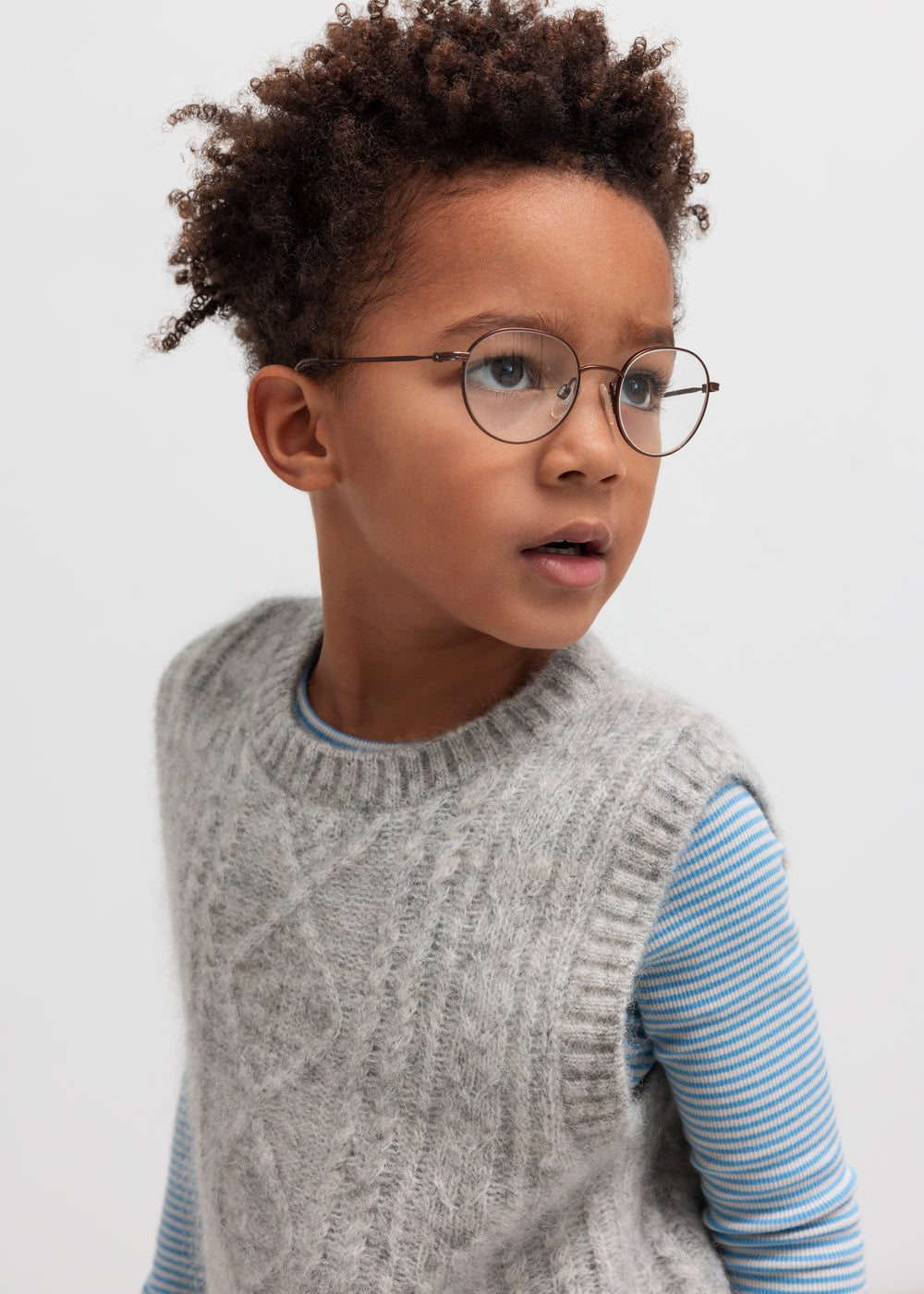 Børn iført grå strikvest over stribet bluse