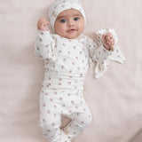 Baby iført blødt babytøj og futter liggende på ryggen