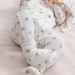 Baby iført blødt babytøj og futter liggende på ryggen