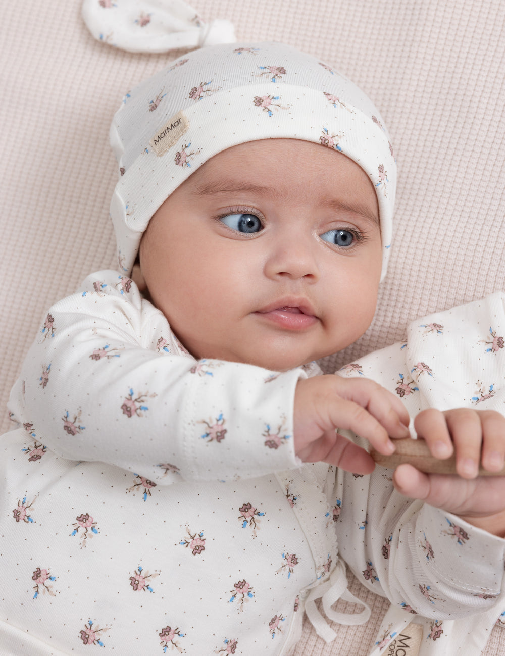 Baby wearing patterned hat and soft suit