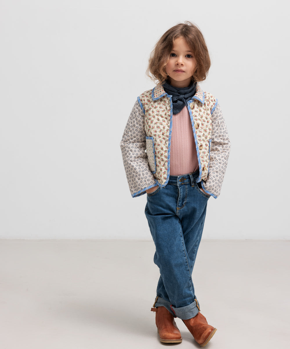 Pige iført rosa pointelle bluse, jakke og tørklæde