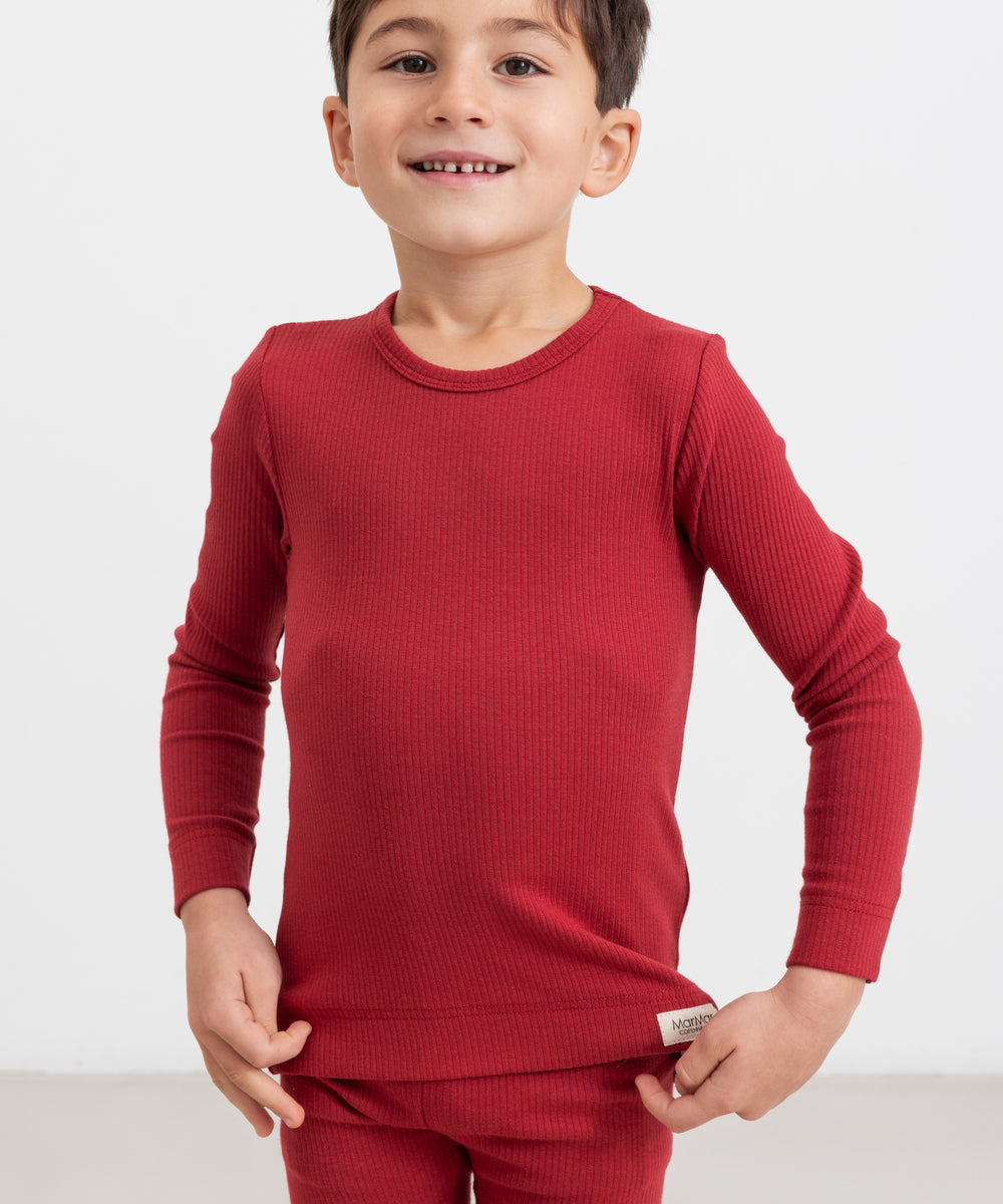 Dreng iført røde ribleggings og langærmet bluse