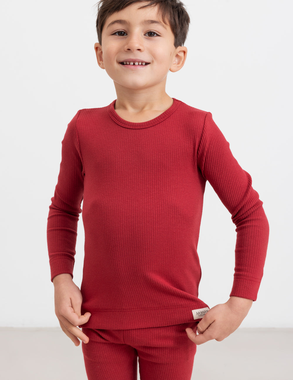 Dreng iført røde bukser og langærmet bluse