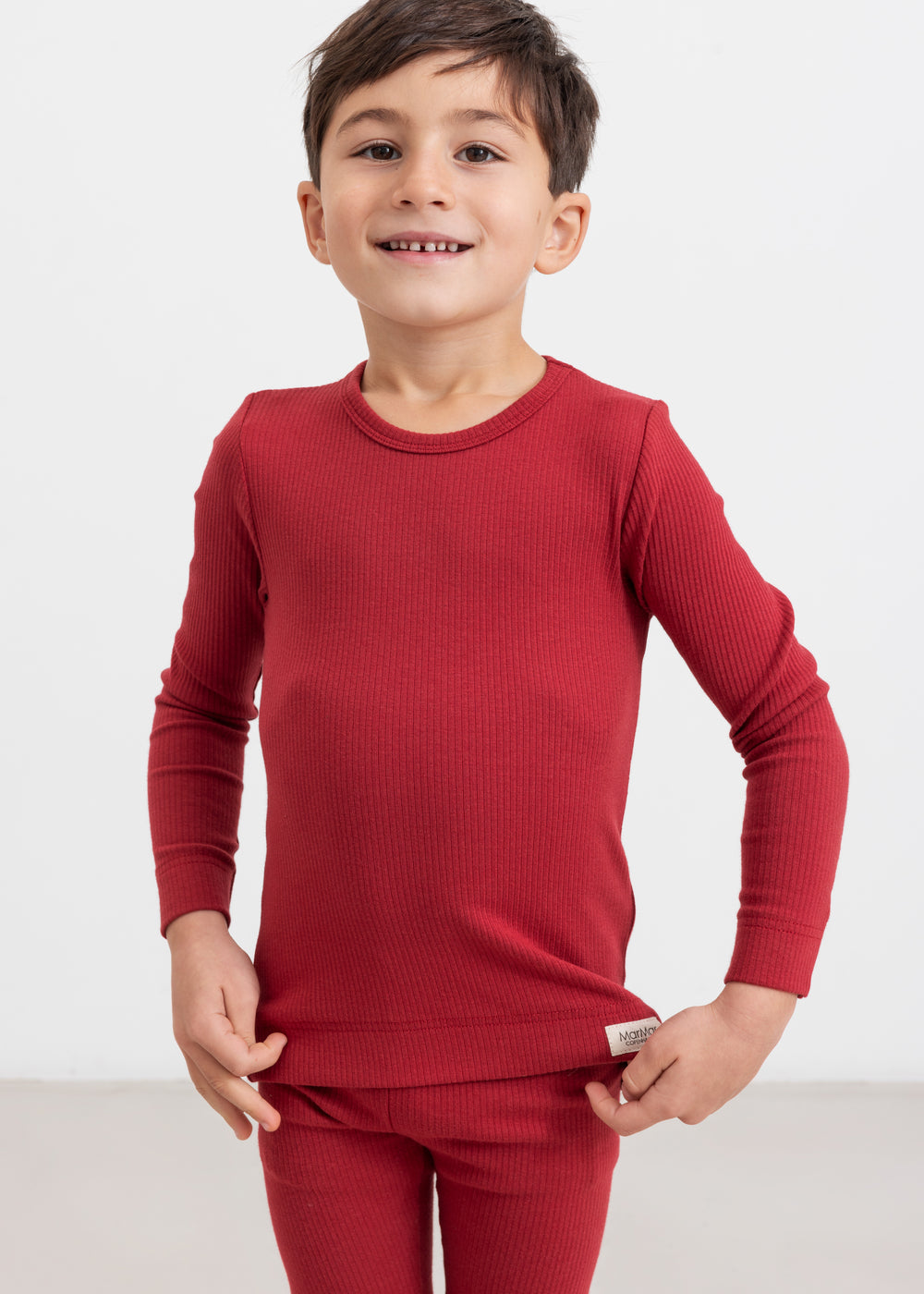 Dreng iført røde ribleggings og langærmet bluse