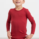 Dreng iført røde ribleggings og langærmet bluse