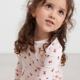 Børn iført cremefarvet julepyjamas med røde juleklokker